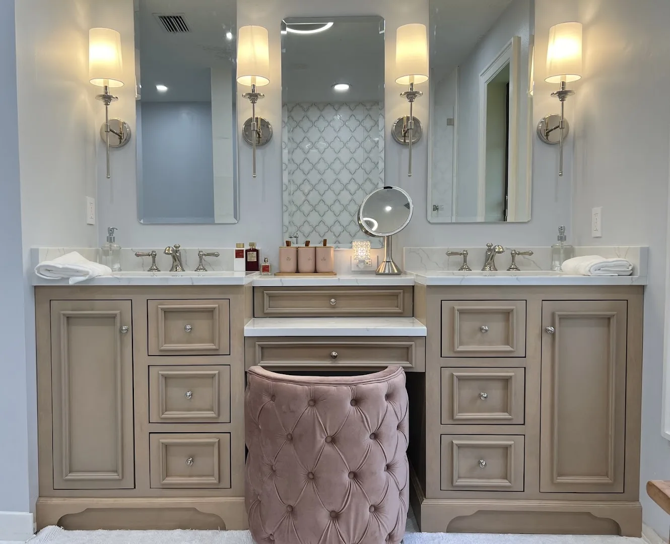 Double vanity with polished-nickel bridge faucets and a makeup desk